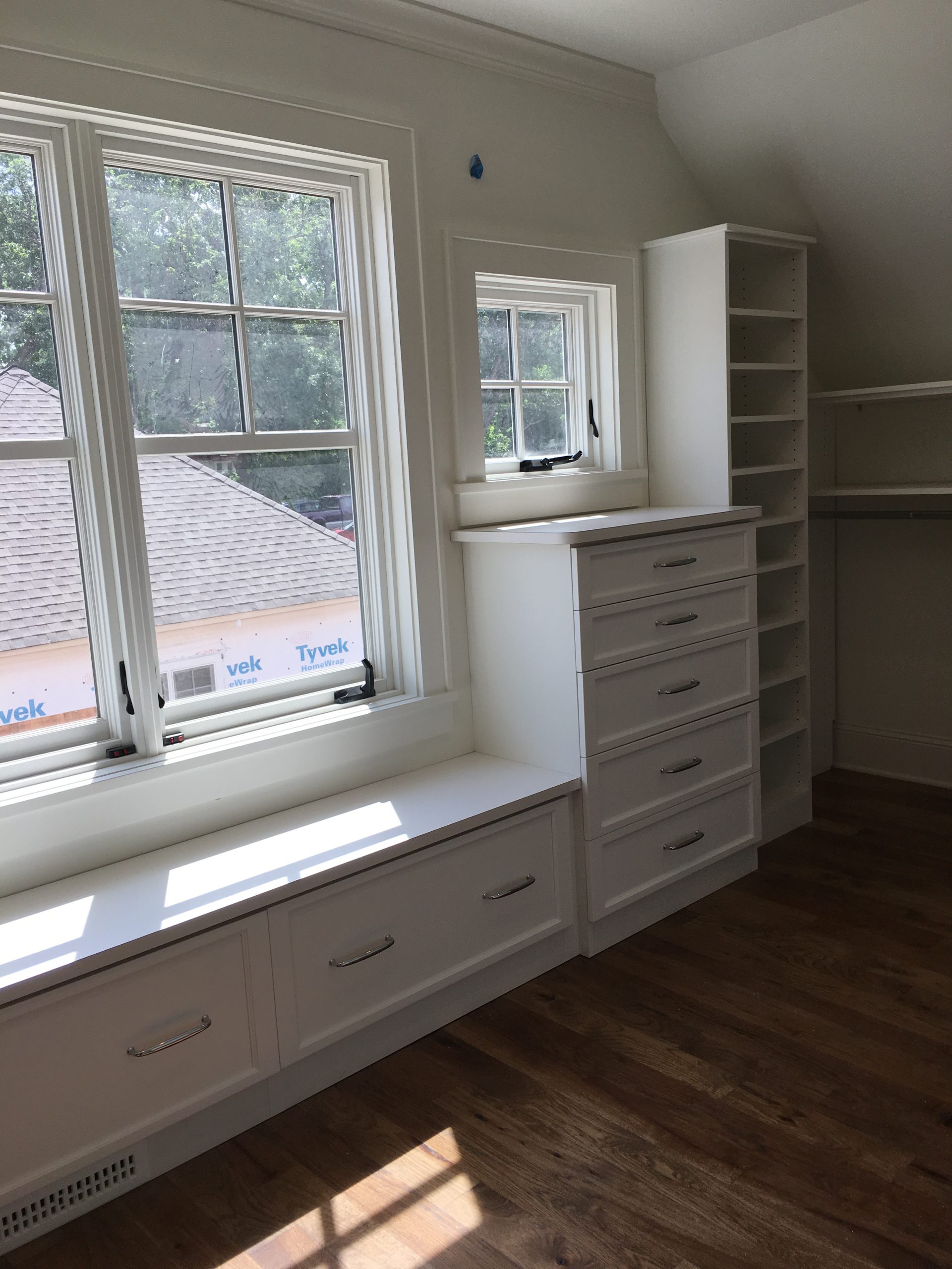 Built-in bench with drawer storage below and a shoe tower alongside, in a Diseno Closets project