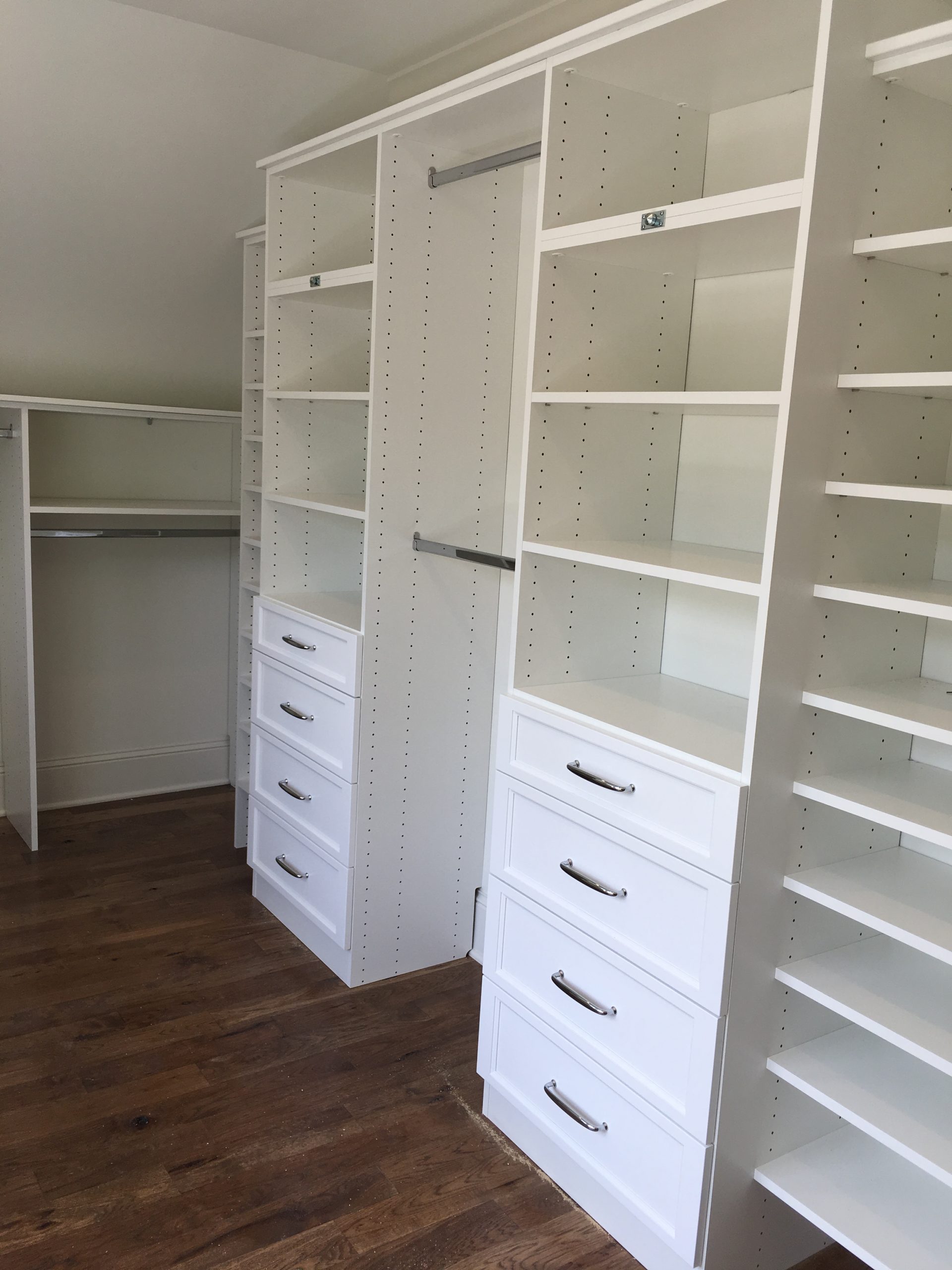 Custom closet with floor-to-ceiling drawer towers and adjustable shelving fitted wall to wall